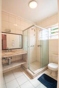 uma casa de banho com uma cabina de duche em vidro e um WC. em Pelotas Bier Hostel em Pelotas