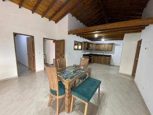 a dining room with a glass table and chairs at Mirador la piedra in Guatapé