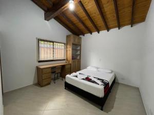 1 dormitorio con cama y escritorio en Mirador la piedra, en Guatapé