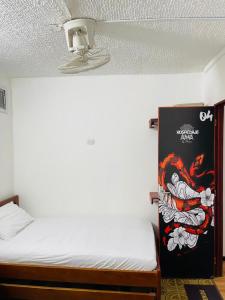 a room with a bed and a painting on the wall at HOSTAL AMA in Leticia +11 photos