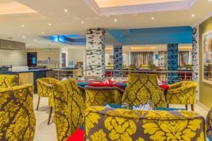 a dining room with yellow chairs and a table at Protea Hotel by Marriott Lagos Kuramo Waters in Lagos