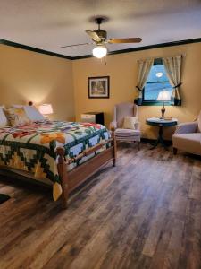 ein Schlafzimmer mit einem Bett, einem Stuhl und einem Fenster in der Unterkunft Moonlight Manor Bed & Breakfast in Floyd