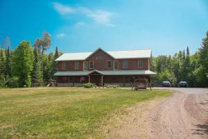 ein großes rotes Haus auf einem Feld mit einer unbefestigten Straße in der Unterkunft Twin Ports Hideaway in Hermantown