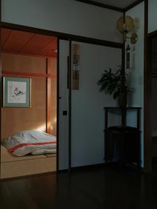 uma porta de vidro deslizante que leva a um quarto com uma cama em 心遊亭ー敬華の間Shin Yu Tei em Kanazawa