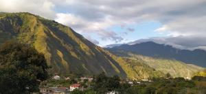 a view of a mountain with a town in front at Casa Vacacional Los Guayacanes in Baños