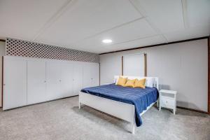 a bedroom with a bed with blue sheets and yellow pillows at Modern Cozy Home 4 min Drive from Notre Dame in South Bend