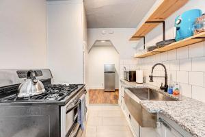 uma cozinha com um fogão e um lavatório em Chic Duplex Haven I Steps From Paseo Arts Dist em Oklahoma City
