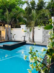 a swimming pool with a white fence and trees at 435 on vale boutique aparthotel in Johannesburg