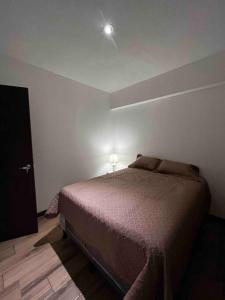 a bedroom with a bed in the corner of a room at Bonito Apartamento en zona exclusiva y tranquila in Quetzaltenango