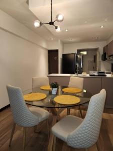 a dining room with a table and chairs and a kitchen at Bonito Apartamento en zona exclusiva y tranquila in Quetzaltenango