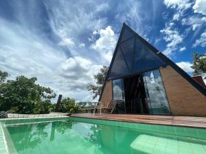una piscina con una casa con una ventana grande en Cabana Energia em Pirenópolis, en Pirenópolis