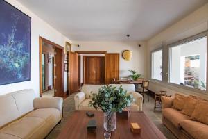 ein Wohnzimmer mit einem Sofa und einem Tisch mit einer Blumenvase in der Unterkunft Villa El Olivo - first line with direct access to the beach in Poris de Abona