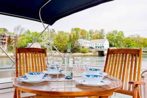 - une table avec une bouteille de vin et des verres sur un bateau dans l'établissement Maine Bed & Boat, Nebi, à Damariscotta