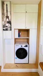 a small kitchen with a washing machine in the corner at Studio 10 min Métro 1 et RER A Vincennes Calme in Vincennes