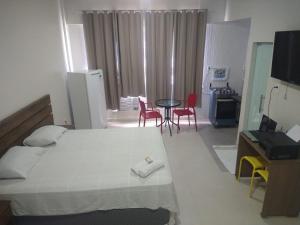 馬瑙斯的住宿－Temporada centro de Manaus 815，卧室配有一张床和一张桌子及椅子