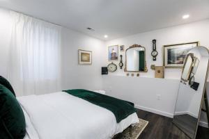 - une chambre blanche avec un lit et un miroir dans l'établissement The Shamrock Retreat:Movie Nights & Kid's Nook 10+, à South Bend