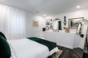 a white bedroom with a bed and a mirror at The Shamrock Retreat:Movie Nights & Kid's Nook 10+ in South Bend