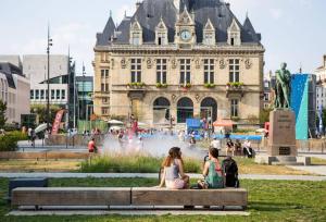 two people sitting on a bench in front of a fountain at Studio 10 min Métro 1 et RER A Vincennes Calme in Vincennes