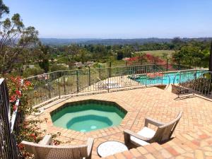 einen großen Pool mit zwei Stühlen und einer Terrasse in der Unterkunft Celebrity Dream Estate in Rancho Santa Fe