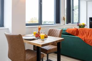 Chic Luxury Apartment near Old Trafford Stadiums Manchester في مانشستر: طاولة طعام مع وعاء من الفواكه وعصير البرتقال