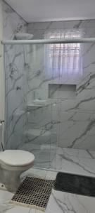 a bathroom with a glass shower with a toilet at Recanto Ursa Maior in Monte Verde