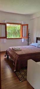 a bedroom with a large bed with a window at Recanto Ursa Maior in Monte Verde