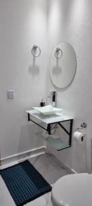 a bathroom with a sink and a mirror and a toilet at Recanto Ursa Maior in Monte Verde