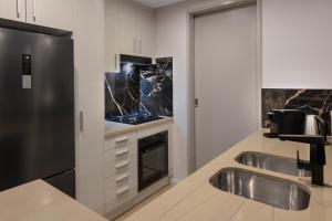 cocina con fregadero y nevera en Meriton Suites Broadbeach, en Gold Coast