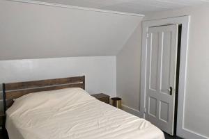 a white bed in a room with a door at Bangor home minutes from airport in Bangor