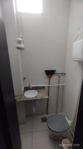 a small bathroom with a sink and a toilet at Apartamento central particular in Lavras