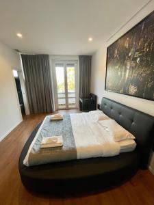 ein großes Bett in einem Schlafzimmer mit einem großen Gemälde an der Wand in der Unterkunft Savoia Luxury Apartment in Mailand