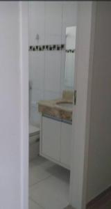 a white kitchen with a sink and a counter at Sobrado duas quadras da praia in Guaratuba +13 photos