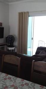 a living room with a couch and a window at Sobrado duas quadras da praia in Guaratuba