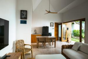 Puspa Ayu Villas & Apartments في كوتا: غرفة معيشة مع أريكة وطاولة