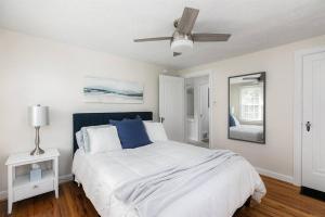 een witte slaapkamer met een bed en een plafondventilator bij The Stay Like a Champion Haven 4BR/3B 7min ND 12+ in South Bend