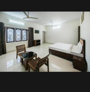 a bedroom with a bed and a table and chairs at OYO Zora Luxury Rooms in Visakhapatnam