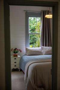 una camera con letto e finestra di Ard Choille Cottages a Mount Macedon