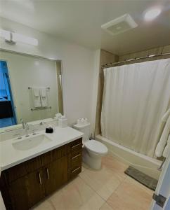 a bathroom with a sink and a toilet and a shower at Semprose Azure Ala Moana in Honolulu