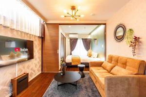 a living room with a couch and a bed at FDS Panache in Osaka