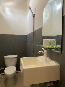 Gili Ilalang Village في غيلي تراوانغان: حمام مع حوض ومرحاض ومرآة
