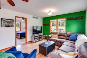 een woonkamer met een bank en een groene muur bij On Campus Home Updated Steps From Hesburgh - 10+ in South Bend