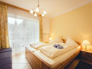 a bed in a room with a large window at Pension Regia in Velden am Wörthersee