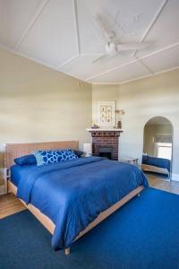 a bedroom with a blue bed and a fireplace at Boutique by the Bay - Beach Wifi Nespresso in Glenelg