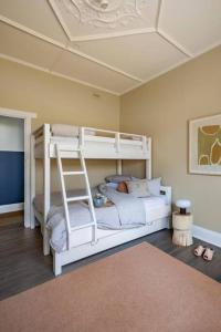 a bedroom with two bunk beds and a ladder at Boutique by the Bay - Beach Wifi Nespresso in Glenelg