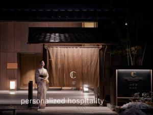 Una donna sul palco di fronte a una tenda di Hotel The Celestine Kyoto Gion a Kyoto