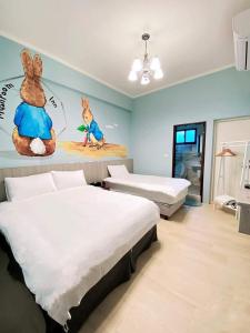 Zimmer mit 2 Betten und einem Wandbild von Kaninchen in der Unterkunft 蘑菇村-童心未泯民宿 in Taitung