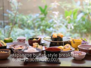 uma mesa coberta com diferentes tipos de alimentos em pratos em Hotel The Celestine Kyoto Gion em Quioto