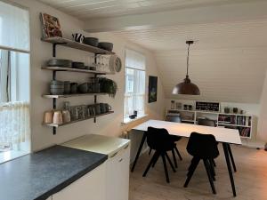 a kitchen with a table and chairs in a room at Apartment downtown - Great View! in Klaksvík