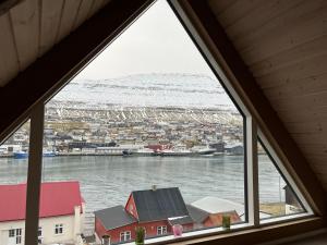 een raam met uitzicht op een haven vanuit een huis bij Apartment downtown - Great View! in Klaksvík