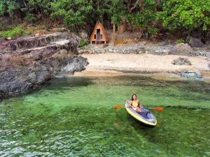 a woman is in a kayak in the water at L'Astrolabe - Private Beach in Baras
